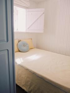 Habitación pequeña con cama con reloj en Cangosta House, en Fão