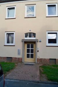 a house with a yellow door and a brick driveway at B-Hostel in Kassel