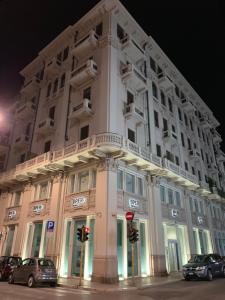 ein großes weißes Gebäude mit davor geparkt in der Unterkunft Berga Exclusive Suite 3 in Bari