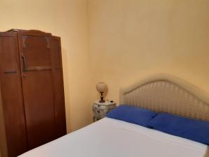sypialnia z łóżkiem z niebieskimi poduszkami i szafką w obiekcie Tenuta la Fresa w mieście Muro Leccese