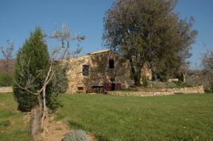 an old stone house in a field with a tree at Romantic House in Greve in Chianti