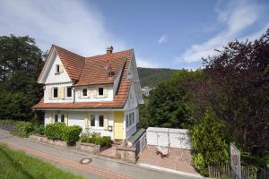 a white house with a brown roof on a street at Villa Sophie in Bad Herrenalb