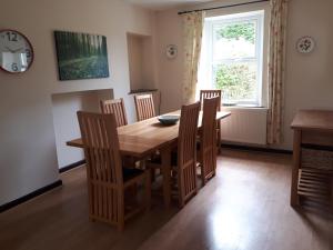 a dining room with a wooden table and chairs at Llandeilo Farmhouse in Llandeilo