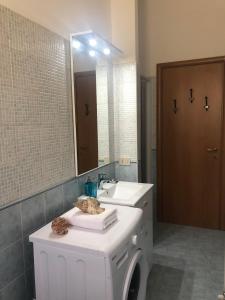 łazienka z białą umywalką i lustrem w obiekcie Central House Terracina w mieście Terracina +16 zdjęć