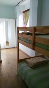 a bedroom with two bunk beds and a mirror at La Peonia casa vacanze in montagna prato verde panorama stupendo Sardegna in Seùlo