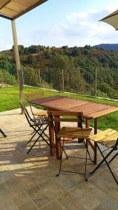 a picnic table and two chairs and an umbrella at La Peonia casa vacanze in montagna prato verde panorama stupendo Sardegna in Seùlo +27 photos