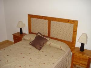 a bedroom with a bed with two nightstands and two lamps at Casa Nueva Carmen in Pendueles
