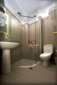 uma casa de banho com um chuveiro, um WC e um lavatório. em Astron Hotel em Lerápetra