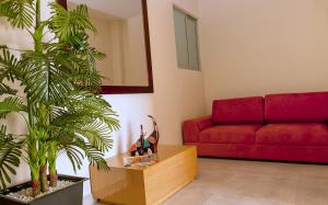 a living room with a red couch and a plant at Hotel Metropolitano Plaza in Valledupar
