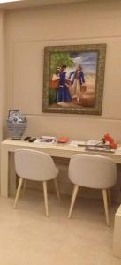 un escritorio con 2 sillas y un cuadro en la pared en Apartamentos AS Malaga centro historico, en Málaga