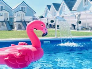 a pink inflatable flamingo in a swimming pool at Domki BALTIC FAMILY basen kidsclub rowery in Mielno +49 photos