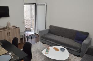 un soggiorno con divano e tavolo di White Tower Apartment a Salonicco