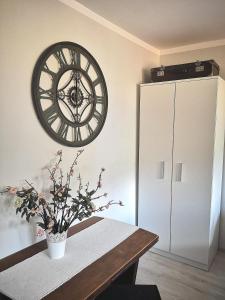シフィエボジンにあるPrzy ratuszuのテーブルと壁に大きな時計が備わる客室です。