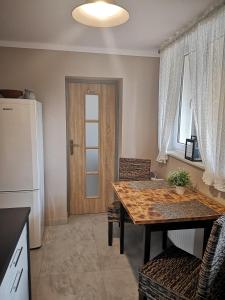 a dining room with a table and a refrigerator at Przy ratuszu in Świebodzin