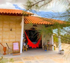 a house with a red hammock on the front of it at Flats Macapá Meu Amor in Luis Correia
