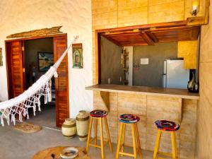 a kitchen with a counter and stools in a room at Flats Macapá Meu Amor in Luis Correia