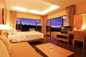 a hotel room with a bed and a television at Islanda Resort Hotel in Ko Mak