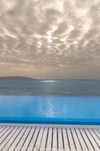 a blue swimming pool with a view of the ocean at Apartamento Frente a Islas Ballestas in Paracas