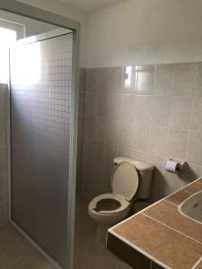 a bathroom with a toilet and a sink at Airport Sleepy Inn in Cancún