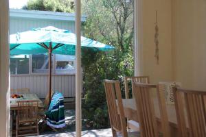 a table with a blue umbrella on a patio at Blairgowrie Beach Escape in Blairgowrie
