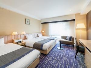 京都市にある京都 新阪急ホテルのベッド2台とデスクが備わるホテルルームです。