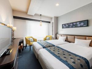 um quarto de hotel com duas camas e uma televisão de ecrã plano em Hotel New Hankyu Kyoto em Quioto