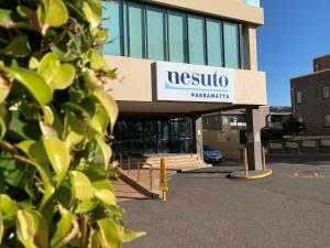 a nissko pharmacy sign in front of a building at Nesuto Parramatta in Sydney