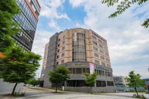 a large office building with a sign on it at Benikea Hotel Bizinn in Wonju