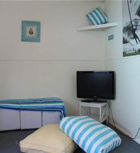 a room with a bed and a tv and a pillow at Blairgowrie Beach Escape in Blairgowrie