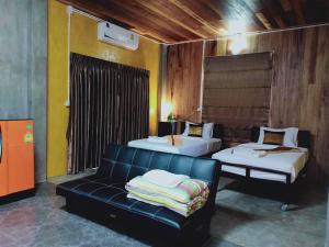 een woonkamer met 2 bedden en een bank bij BAAN9NAN Home Lodge in Nan