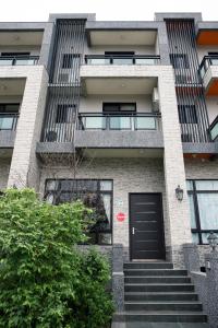 an apartment building with a black door and stairs at DoMo Yilan in Yuanshan