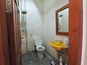 a bathroom with a sink and a toilet and a mirror at Omah Pitoe Yogya Homestay in Yogyakarta