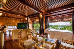 une chambre avec un lit, une table et des chaises dans l'établissement Sankofa Village Hill Resort & Spa, à Hue