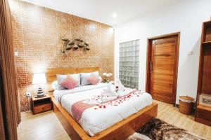 a bedroom with a bed and a brick wall at Dong Jegeg Canggu in Canggu