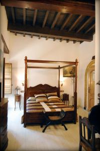 a bedroom with a wooden bed with pillows on it at Pensión Alfin in Granada