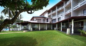 duży budynek z trawnikiem przed nim w obiekcie Berjaya Hotel Colombo w mieście Mount Lavinia