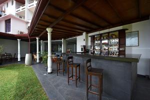 a bar with wooden stools at a restaurant at Berjaya Hotel Colombo in Mount Lavinia
