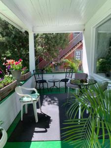 un porche cubierto con sillas, mesas y plantas en Quaint & Cozy Accommodation en Edmonton