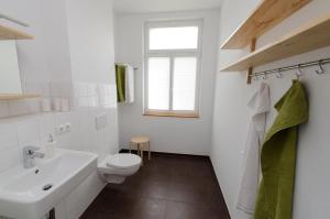 a white bathroom with a toilet and a sink at FeWo Markranstädt in Markranstädt