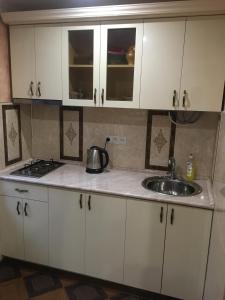 eine Küche mit weißen Schränken und einem Waschbecken in der Unterkunft DILIJAN Apartment 2 in Dilidschan