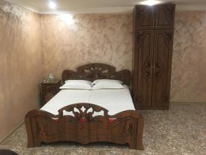 a bedroom with a wooden bed and a wooden cabinet at DILIJAN Apartment in Dilijan