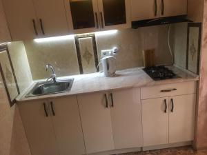 a kitchen with white cabinets and a sink at DILIJAN Apartment in Dilijan +41 photos