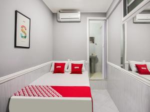 Habitación blanca con almohadas rojas en la cama en OYO Hotel Boneville, São Paulo, en São Paulo