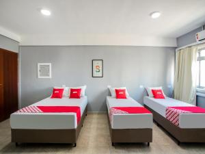 two beds in a room with red pillows at OYO Hotel Boneville, São Paulo in São Paulo