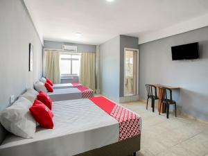 two beds with red pillows in a bedroom at OYO Hotel Boneville, São Paulo in Sao Paulo