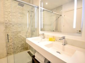 uma casa de banho com um lavatório e um chuveiro em Hotel Legado Alcazar em Sevilha