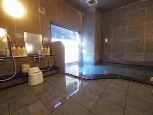La salle de bains est pourvue d'une douche, d'une fenêtre et d'un lavabo. dans l'établissement Hotel Route-Inn Kitakami Ekimae, à Kitakami