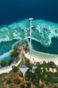 eine Insel mit einem Kreuz mitten im Ozean in der Unterkunft The Seraya Resort Komodo in Labuan Bajo