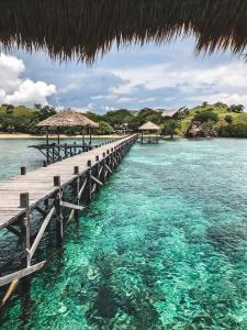 a pier in the ocean with turquoise water at The Seraya Resort Komodo in Labuan Bajo