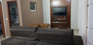 uma sala de estar com um sofá e uma TV de tela plana em Casa Magnífica em Olímpia